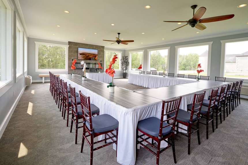 The 36-seat conference room in the Mansion, daylight on three sides with a screen at the far end