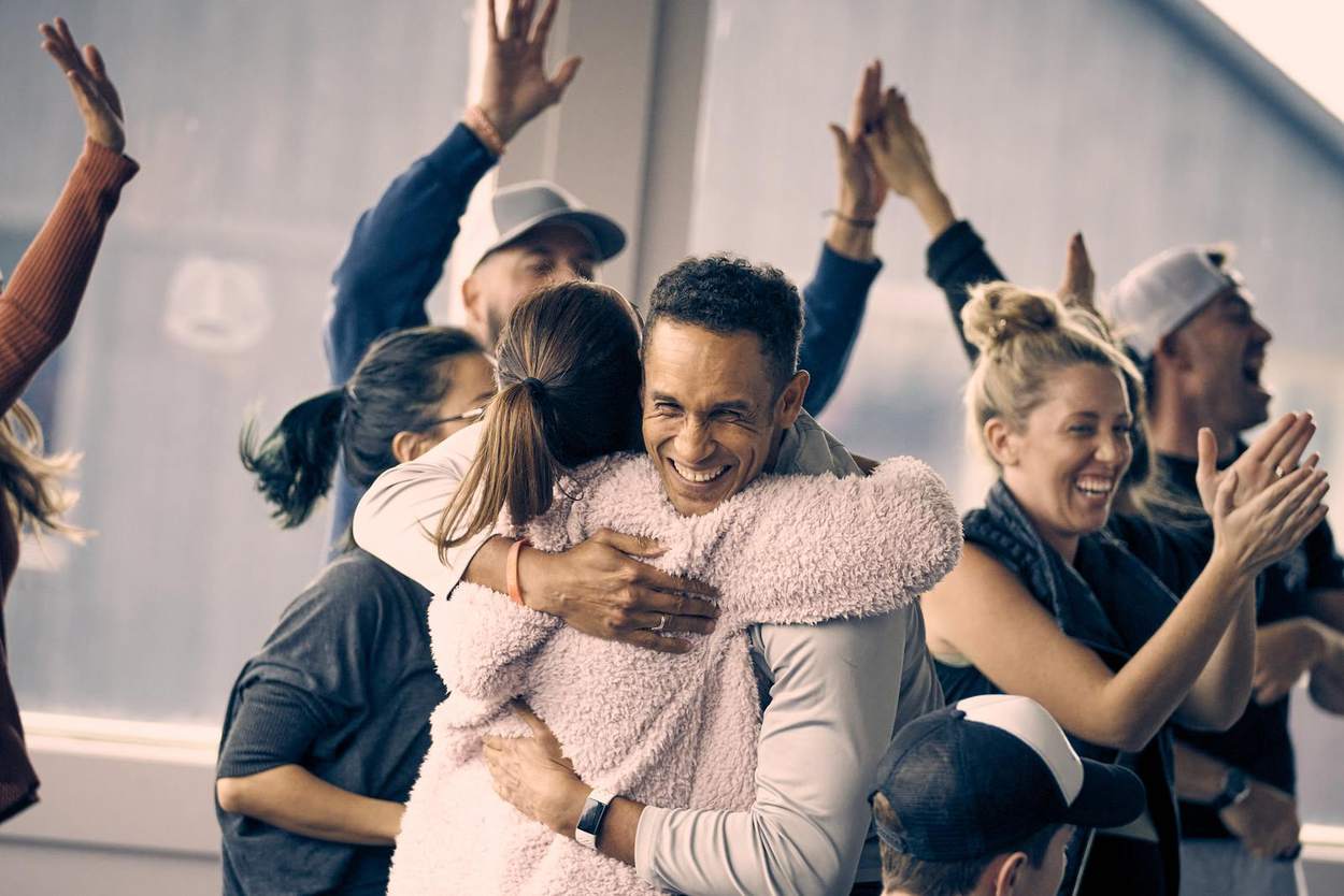 A team at Hilltop mid-celebration, hugging and applauding during a group activity